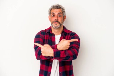 Beyaz arka plan noktalarında izole edilmiş orta yaşlı beyaz adam iki seçenek arasında seçim yapmaya çalışıyor..
