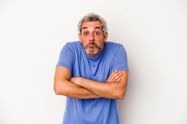 Beyaz arka planda izole edilmiş orta yaşlı beyaz bir adam omuz silkiyor ve gözleri açık..