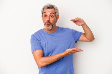 Beyaz arka planda izole edilmiş orta yaşlı beyaz adam iki eliyle bir şey tutuyor, ürün sunumu..