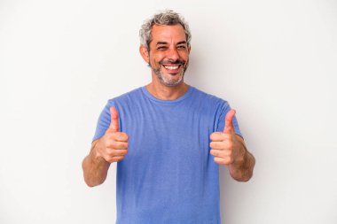 Beyaz arka planda izole edilmiş orta yaşlı beyaz bir adam gülümsüyor ve başparmağını kaldırıyor.