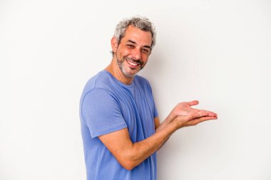 Beyaz arka planda izole edilmiş orta yaşlı beyaz bir adam palmiyesinde bir kopya alanı tutuyor..