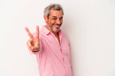 Beyaz arka planda izole edilmiş orta yaşlı beyaz bir adam neşeli ve kaygısız parmaklarıyla barış sembolü gösteriyor..