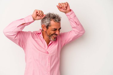 Beyaz arka planda izole edilmiş orta yaşlı beyaz bir adam özel bir günü kutluyor, atlıyor ve enerjiyle kollarını kaldırıyor..