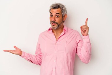 Beyaz arka planda izole edilmiş orta yaşlı beyaz bir adam elinde bir ürün tutuyor..