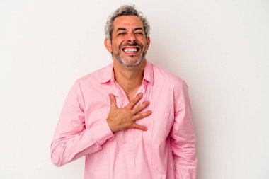 Beyaz arka planda izole edilmiş orta yaşlı beyaz bir adam elini göğsünde tutarak kahkahalar atıyor..