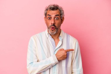 Pembe arka planda izole edilmiş orta yaşlı beyaz bir adam.