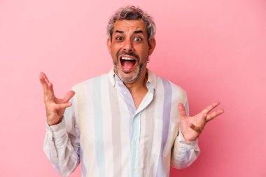 Orta yaşlı beyaz bir adam pembe arka planda izole edilmiş gökyüzüne haykırıyor, yukarı bakıyor, hayal kırıklığına uğramış..