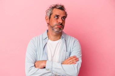 Pembe arka planda izole edilmiş orta yaşlı beyaz bir adam tekrarlanan bir görevden bıktı..