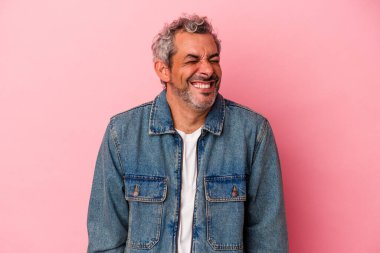 Orta yaşlı beyaz bir adam pembe arka planda izole edilmiş. Kahkahalar atıyor ve gözlerini kapatıyor. Rahatlamış ve mutlu hissediyor..