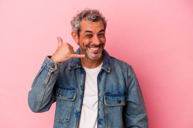 Pembe arka planda izole edilmiş orta yaşlı beyaz bir adam parmakları olan bir cep telefonu hareketi gösteriyor..