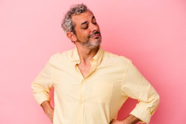 Pembe arka planda izole edilmiş orta yaşlı beyaz adam hedeflerine ve amaçlarına ulaşma hayali kuruyor.