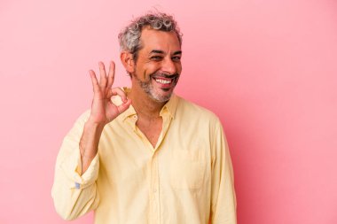 Orta yaşlı beyaz bir adam pembe arka planda izole edilmiş neşeli ve kendinden emin..