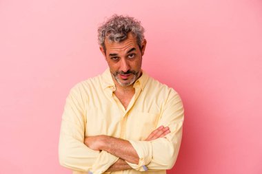 Pembe arka planda izole edilmiş orta yaşlı, yorgun ve dinlenmeye ihtiyacı olan beyaz bir adam..