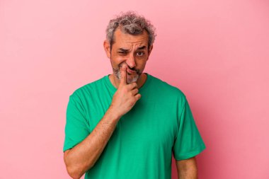 Orta yaşlı beyaz bir adam pembe arka planda izole edilmiş düşünüyor, yukarı bakıyor, yansıtıyor, düşünüyor, bir fantezisi var..