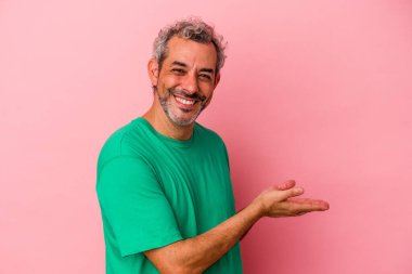 Pembe arka planda izole edilmiş orta yaşlı beyaz bir adam elinde bir fotokopi odası tutuyor..