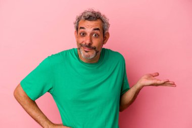 Pembe arka planda izole edilmiş orta yaşlı beyaz bir adam bir palmiye üzerinde fotokopi alanı ve belinde başka bir el tutuyor..