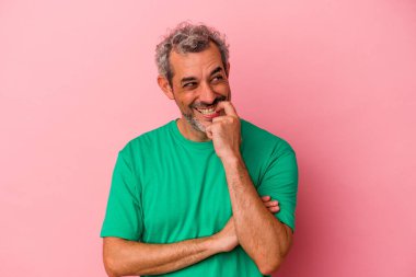 Orta yaşlı beyaz bir adam pembe arka planda izole edilmiş rahat bir şekilde fotokopi odasına bakan bir şey düşünüyor..