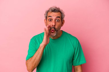 Pembe arka planda izole edilmiş orta yaşlı beyaz bir adam gizli bir sıcak fren haberinin olduğunu söylüyor.