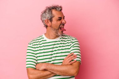 Orta yaşlı beyaz bir adam pembe arka planda izole edilmiş komik ve dost canlısı bir dil kullanıyor..