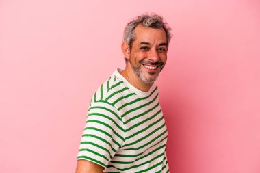 Orta yaşlı, beyaz bir adam pembe arka planda izole edilmiş. Kendine güvenen, ellerini kalçasından ayırmayan..