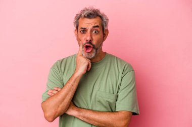 Pembe arka planda soyutlanmış orta yaşlı beyaz bir adam. Harika bir fikri var, yaratıcılık kavramı..