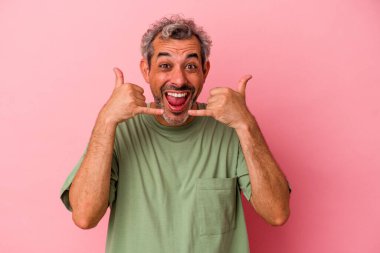 Pembe arka planda izole edilmiş orta yaşlı beyaz bir adam parmakları olan bir cep telefonu hareketi gösteriyor..