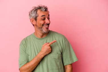 Pembe arka planda soyutlanmış orta yaşlı beyaz bir adam gülümsüyor, neşeli ve keyifli görünüyor..