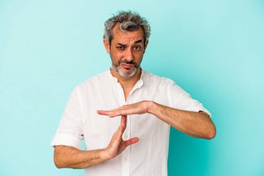 Mavi arka planda izole edilmiş orta yaşlı beyaz bir adam bir mola hareketi gösteriyor..
