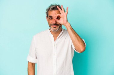 Mavi arka planda izole edilmiş orta yaşlı beyaz bir adam heyecanlı..