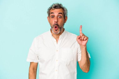 Mavi arka planda soyutlanmış orta yaşlı beyaz bir adamın bir fikri, ilham konsepti var..