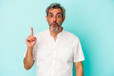 Mavi arka planda soyutlanmış orta yaşlı beyaz bir adamın harika bir fikri var, yaratıcılık kavramı..