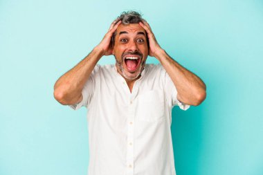 Mavi arka planda izole edilmiş orta yaşlı beyaz bir adam çığlık atıyor, çok heyecanlı, tutkulu, bir şeyden memnun..