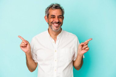 Mavi arka planda izole edilmiş orta yaşlı beyaz bir adam farklı fotokopi alanlarını gösteriyor, birini seçiyor, parmaklarıyla gösteriyor..