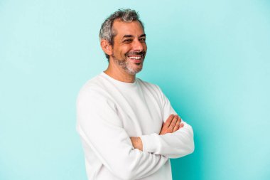 Mavi arka planda izole edilmiş orta yaşlı beyaz adam mutlu, güler yüzlü ve neşeli..