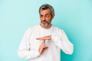 Mavi arka planda izole edilmiş orta yaşlı beyaz bir adam bir mola hareketi gösteriyor..