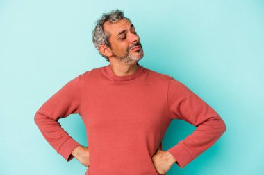 Mavi arka planda izole edilmiş orta yaşlı beyaz adam hedeflerine ve amaçlarına ulaşmayı hayal ediyor.