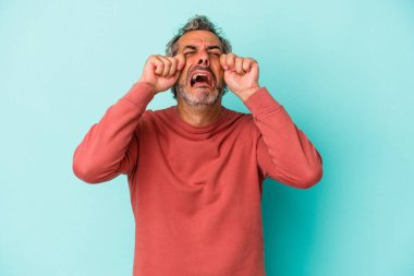 Orta yaşlı, beyaz bir adam mavi arka planda yalnızmış sızlanıyor ve ağlıyormuş..