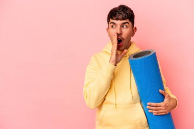 Pembe arka planda izole edilmiş bir spor paspası tutan melez genç adam gizli bir fren haberinin olduğunu söylüyor.