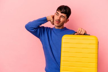 Genç melez adam pembe arka planda tek başına seyahat edecek kafasının arkasına dokunacak, düşünecek ve bir seçim yapacak..