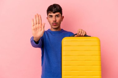 Genç melez adam pembe arka planda tek başına seyahat edecek elini uzatıp dur işareti verecek ve bu da seni engelleyecek..