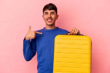 Genç melez adam pembe arka planda tek başına seyahat edecek. Bir gömlek fotokopisini elle gösterecek. Gururlu ve kendinden emin.