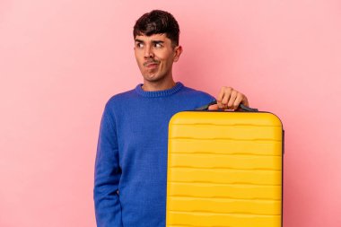 Genç melez adam pembe arka planda tek başına seyahat edecek. Kafası karışmış, kuşkulu ve kendinden emin değil..