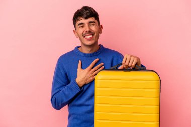 Genç melez adam pembe arka planda tek başına seyahat edecek. Gülecek ve eğlenecek..