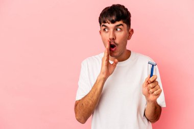 Pembe arka planda jilet tutan genç melez adam gizli bir sıcak fren haberinin olduğunu ve kenara baktığını söylüyor.