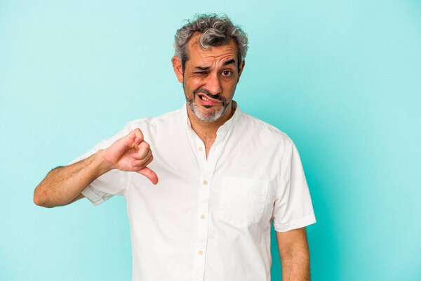 Middle age caucasian man isolated on blue background  showing thumb down, disappointment concept.