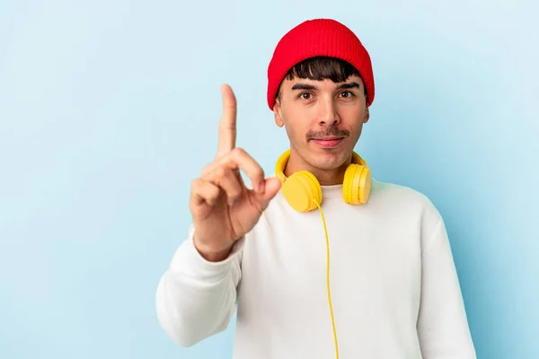 Ung Blandras Man Lyssnar Musik Isolerad Blå Bakgrund Visar Nummer — Stockfoto