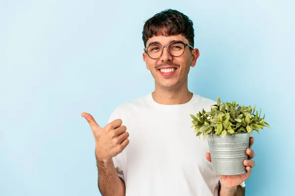 Jonge Gemengde Ras Man Met Een Plant Geïsoleerd Blauwe Achtergrond — Stockfoto