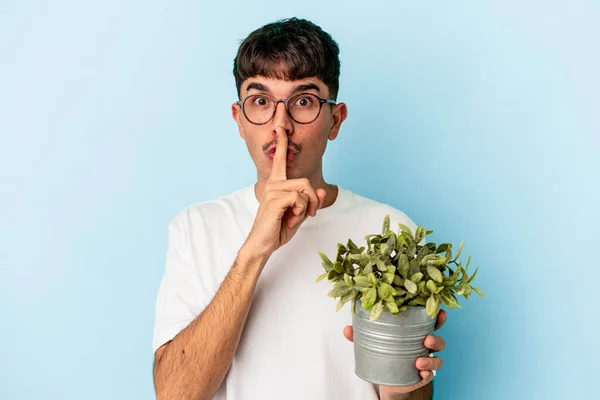 Mladý Smíšený Rasový Muž Držící Rostlinu Izolovanou Modrém Pozadí Držící — Stock fotografie