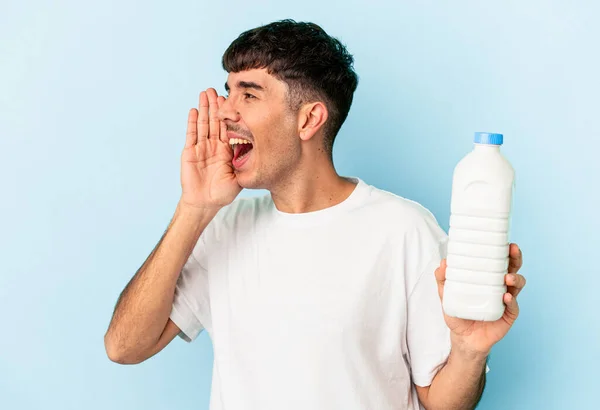 Jonge Gemengde Ras Man Met Een Fles Melk Geïsoleerd Blauwe — Stockfoto
