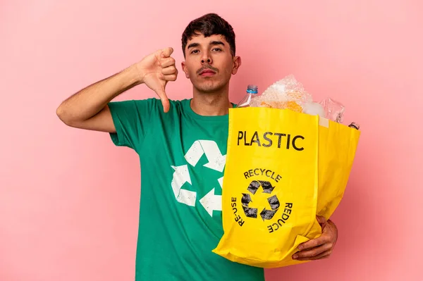 Jonge Gemengde Ras Man Gerecycled Plastic Geïsoleerd Roze Achtergrond Toont — Stockfoto